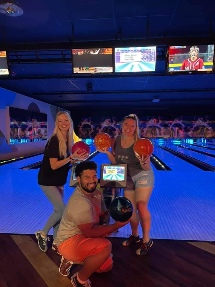 Survivors posing with bowling balls after playing the game.