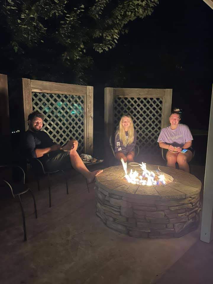 Survivors hanging out around the fire pit at night.